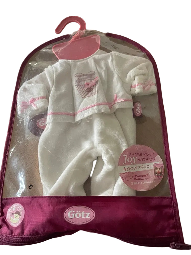 Baby outfit in clear packaging with pink accents on a wooden surface